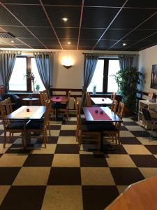 ein Restaurant mit Tischen und Stühlen auf einem karierten Boden in der Unterkunft Euroway Hotel in Göteborg