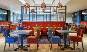 a restaurant with tables and chairs and a bar at Leonardo Hotel Cheltenham in Cheltenham