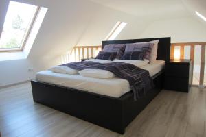 a bedroom with a large bed with purple pillows at Appartement Mezzanine in Hévíz