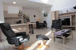 uma sala de estar com cadeiras pretas e uma mesa em Appartement Mezzanine em Hévíz