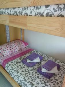 a bunk bed with towels on top of it at Casetta next to the Creek Dino Buzzati in Belluno