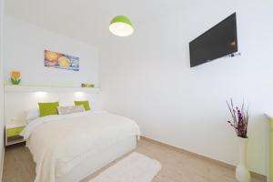 ein weißes Schlafzimmer mit einem Bett und einem Flachbild-TV in der Unterkunft Apartment Lea in Dubrovnik