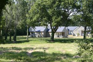 a house in the middle of a field with trees at Village Vacances Chateau de Tréambert in Mesquer