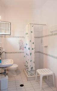 a bathroom with a toilet and a shower curtain at Syraina Apartments in Skiathos Town