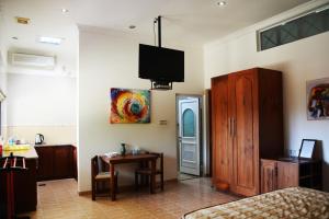a bedroom with a bed and a table and a tv at The Hilltop Boosa in Galle
