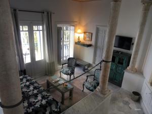 a living room with chairs and a couch and a tv at La Villa Bleue-Sidi Bou Said in Sidi Bou Saïd