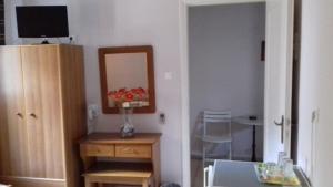a room with a mirror and a vase of flowers on a table at Kabanis Rooms in Ermoupoli +31 photos