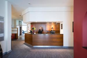 two women standing at a reception desk in a lobby at Bilderberg Grand Hotel Wientjes in Zwolle