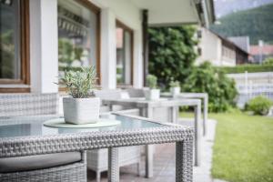 a glass table with a potted plant on a patio at Boutique Hotel Am Park in Valdaora