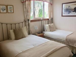 1 dormitorio con 2 camas y ventana en Abermar Guest House en Inverness