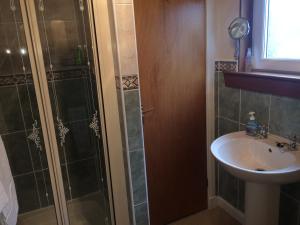 y baño con ducha y lavamanos. en Abermar Guest House en Inverness