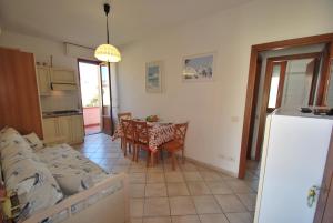 a kitchen and dining room with a table and chairs at Appartamenti Camelia e Gabry - Zona mare con posti auto e terrazze in Marina di Campo