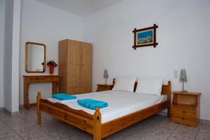 a bedroom with a wooden bed and a mirror at Syraina Apartments in Skiathos Town
