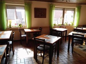 a dining room with wooden tables and green curtains at Pension Grübel in Lindau