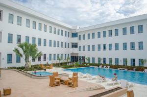 a large white building with a swimming pool at Hotel Las Olas Mamonal in Cartagena de Indias