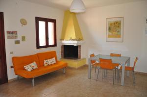 - un salon avec un canapé, une table et une cheminée dans l'établissement Casa Vacanze Sole e Mare, à Porto Cesareo