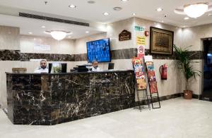 two men sitting at a counter in a restaurant at Rolana Furnished Apartments in Jeddah