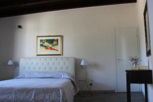 PartannaにあるVilletta Valle del Belìceのベッドルーム1室(ベッド1台付)が備わります。壁に絵が飾られています。