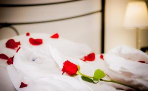 a bunch of red roses on a bed at Hotel Centrale in Trieste