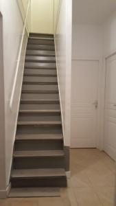 a staircase in a room with white walls at Chambres à PARIS in Ivry-sur-Seine