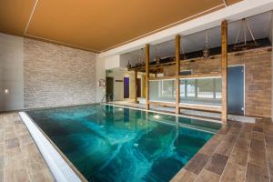 an indoor pool with blue water in a building at Relax hotel Valaška in Horní Bečva