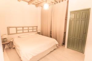 タリファにあるApartamento Siroccoのベッドルーム(白いベッド1台、緑のドア付)