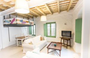 a living room with white furniture and a loft bed at Apartamento Sirocco in Tarifa