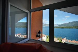 a room with a window with a view of the water at Apartments Dragojević in Tivat