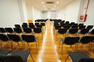 an empty room with black chairs and a wooden floor at Oceano Atlantico Apartamentos Turisticos in Portimão