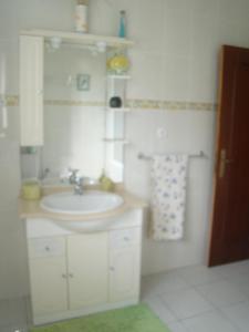 a white bathroom with a sink and a mirror at Casa das Merces in Angra do Heroísmo +32 photos