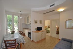 a kitchen and living room with a table and a dining room at Appartamenti Olivo - 100 mt dal mare con aria condizionata in Marina di Campo