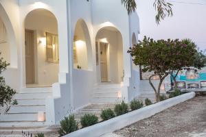 a white house with white walls and stairs at Aspries Suites in Piso Livadi