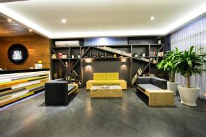 a living room with couches and chairs and shelves at Hotel Perla Central in Guadalajara