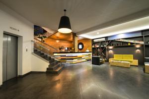 a living room with a staircase and a yellow couch at Hotel Perla Central in Guadalajara