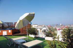 a patio with an umbrella and a table and chairs at Aparthotel Touring in Grado