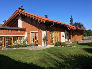 una casa con un patio de hierba delante de ella en Haus Erika en Oberreute