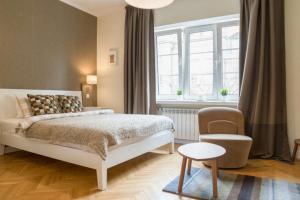 a bedroom with a bed and a chair and a window at Old Town Warsaw Joanna's Apartments in Warsaw