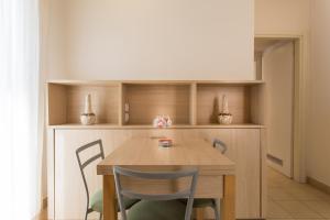 a dining room with a wooden table and chairs at Wally Residence in Rimini