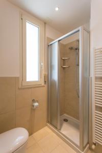 a bathroom with a shower with a toilet and a window at Wally Residence in Rimini