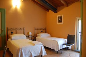 B&B Sant'Antonio في Gramignazzo: سريرين في غرفة بجدران برتقالية