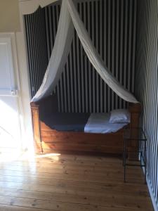uma cama com uma rede mosquiteira num quarto em Le Clos Boutenelle em Éperlecques