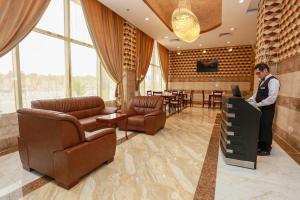 a man standing at a podium in a hotel lobby at Hala Inn Arar Hotel in Arar