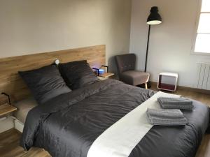 - une chambre avec un grand lit et une chaise dans l'établissement Appartements Les Rochelais, à La Rochelle