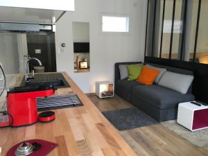 ein Wohnzimmer mit Couch und Küche in der Unterkunft Appartements Les Rochelais in La Rochelle