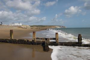 a beach with a pier and the ocean at The Sandown - Seafront, Sandown, Isle of Wight - CAR FERRY TICKET from 109 Pounds in Sandown