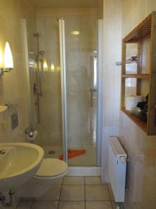 a bathroom with a shower and a toilet and a sink at Fishermans in Borkum +59 photos