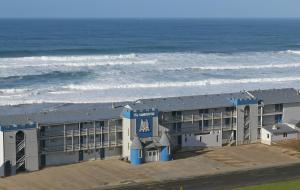 a building on the beach next to the ocean at The Sandcastle Beachfront Hotel in Lincoln City