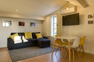 uma sala de estar com um sofá e uma mesa em Ribeira Cinema Apartments no Porto