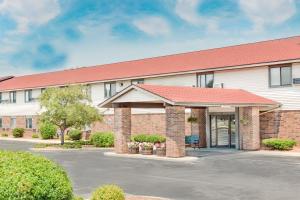 a building with a parking lot in front of it at Super 8 by Wyndham Green Bay Near Stadium in Green Bay