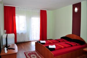 Schlafzimmer mit einem großen Bett und roten Vorhängen in der Unterkunft Casa Otilia in Cluj-Napoca